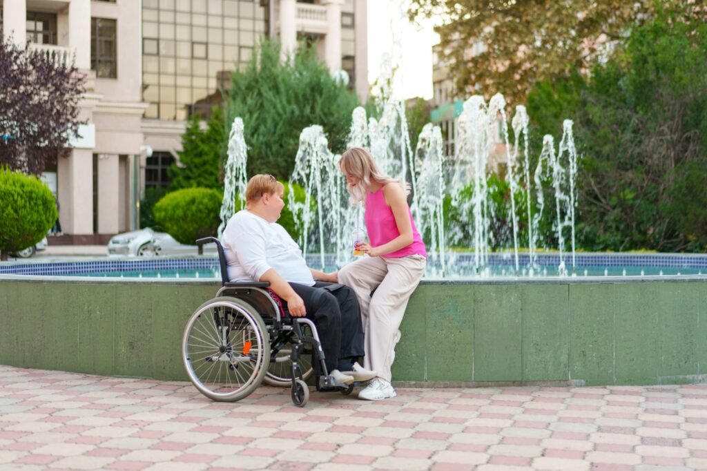 Young daughter taking care of her mother with disability sitting in wheelchair